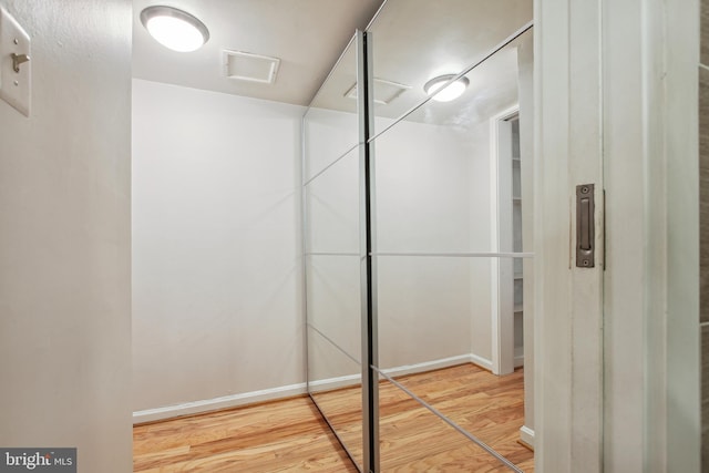 bathroom featuring wood finished floors, visible vents, and baseboards