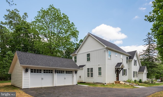 670 Leopard Rd, Berwyn, PA 19312 - view of property exterior with an outbuilding, board and batten siding, roof with shingles, and a detached garage