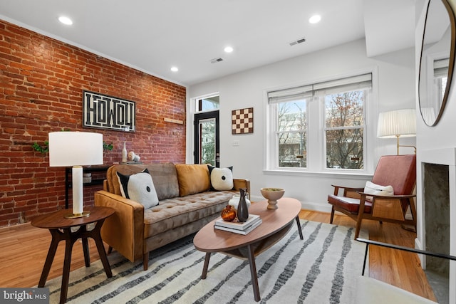 living room featuring light hardwood / wood-style floors and brick wall