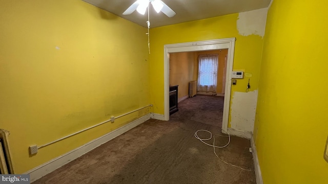 hall featuring dark carpet and radiator