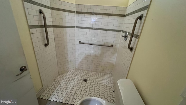 bathroom with tiled shower and toilet