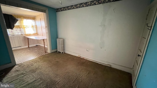 unfurnished room with radiator heating unit