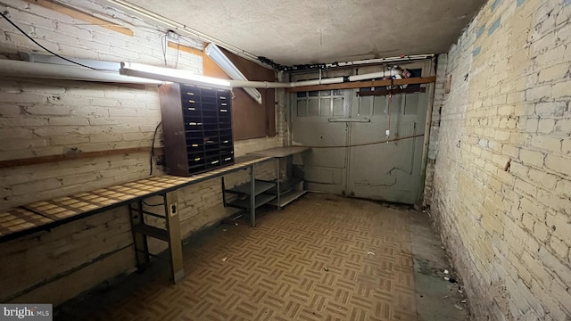 basement with parquet flooring and brick wall