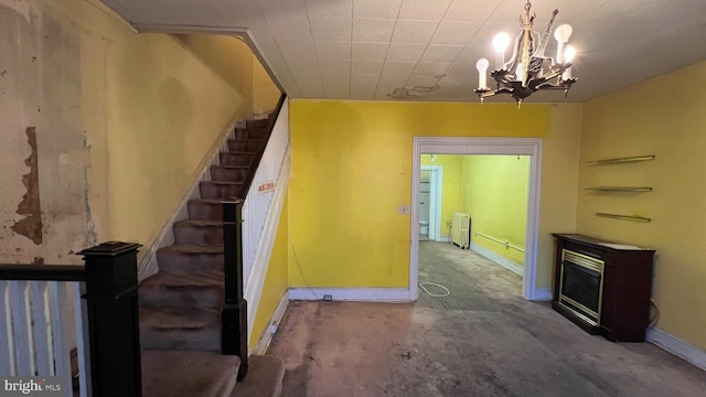 stairway with a notable chandelier