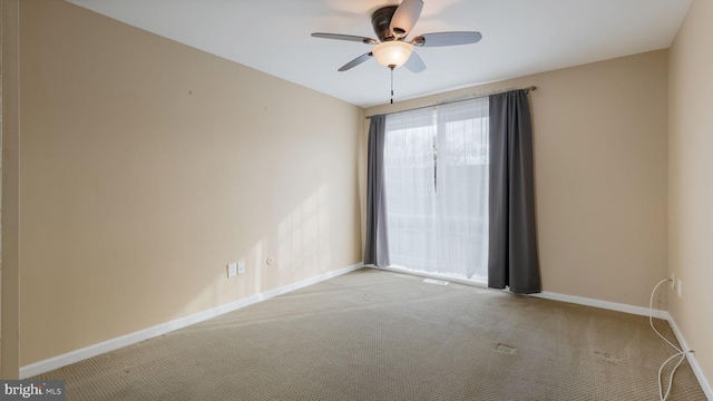 carpeted spare room featuring ceiling fan