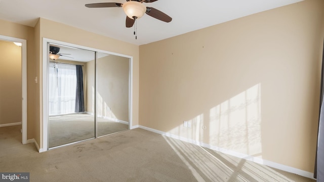 unfurnished bedroom with a closet, ceiling fan, and light colored carpet