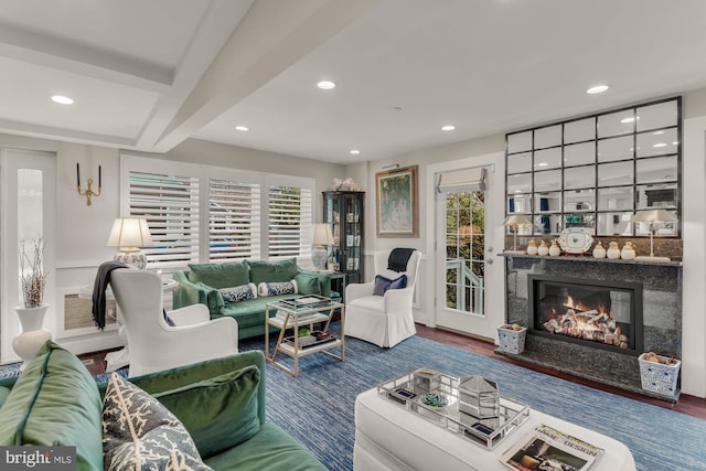 living room featuring a premium fireplace, wood finished floors, beam ceiling, and recessed lighting