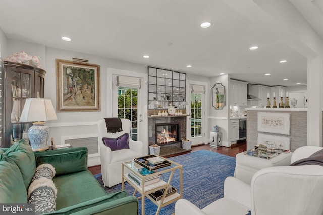 living room featuring a fireplace, dark wood-style flooring, and recessed lighting