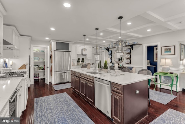 kitchen with dark wood finished floors, white cabinetry, stainless steel appliances, and a sink