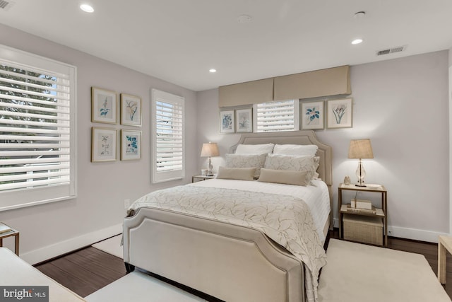 bedroom with baseboards, visible vents, wood finished floors, and recessed lighting