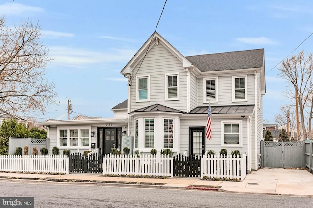 traditional-style house with metal roof, a standing seam roof, a gate, and a fenced front yard