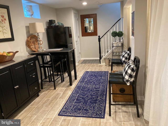 interior space featuring wood tiled floor, stairs, and baseboards