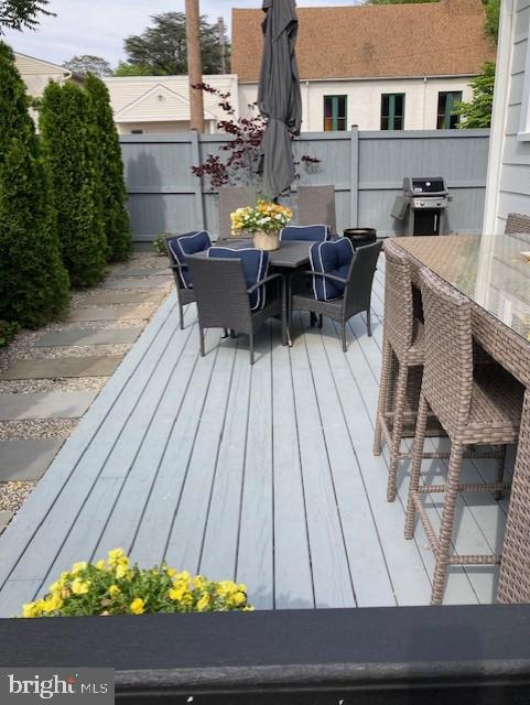 deck with fence, area for grilling, and outdoor dining space