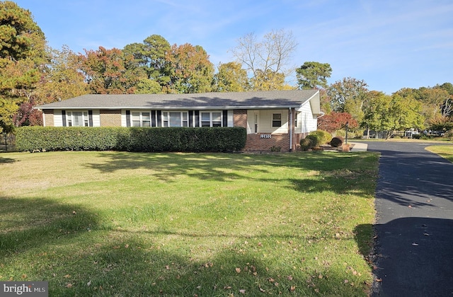 ranch-style home featuring a front lawn and brick siding