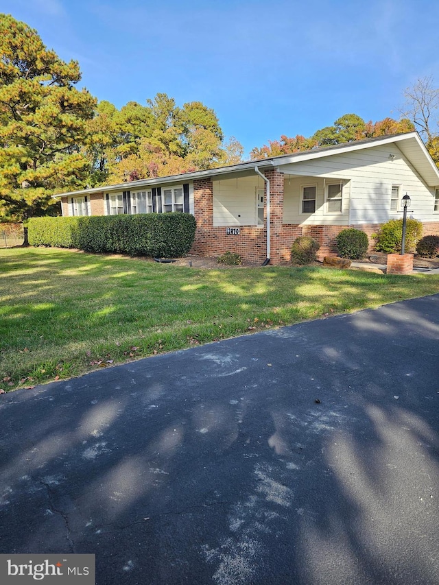 view of front of property featuring brick siding and a front yard