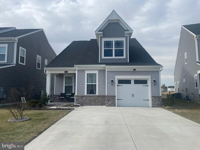 craftsman inspired home with driveway, a porch, a front lawn, stone siding, and board and batten siding