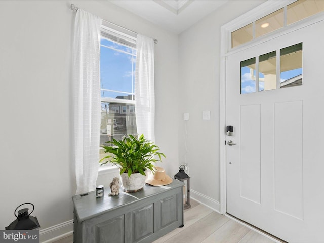 foyer entrance with baseboards and light wood-style flooring