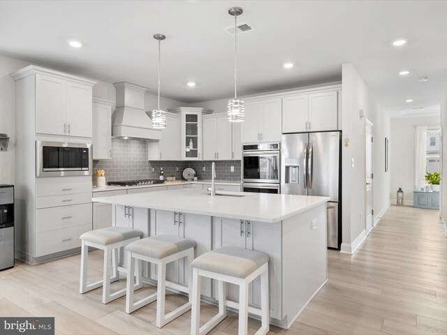 33423 Hickory St, Millsboro, DE 19966 - kitchen with premium range hood, visible vents, light wood-style flooring, a sink, and stainless steel appliances
