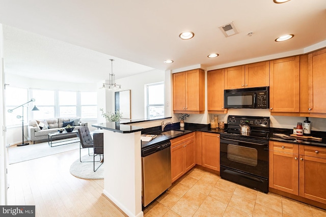 kitchen with open floor plan, black appliances, dark countertops, and brown cabinets