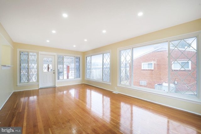 unfurnished living room with recessed lighting, visible vents, light wood-style flooring, and baseboards