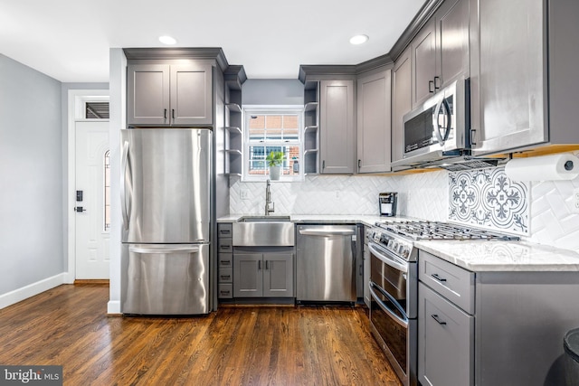 kitchen with gray cabinets, appliances with stainless steel finishes, open shelves, and a sink