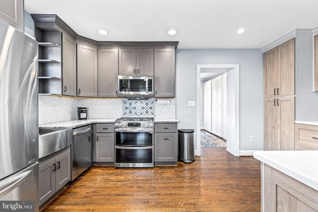 kitchen featuring gray cabinetry, stainless steel appliances, dark wood-style flooring, decorative backsplash, and open shelves