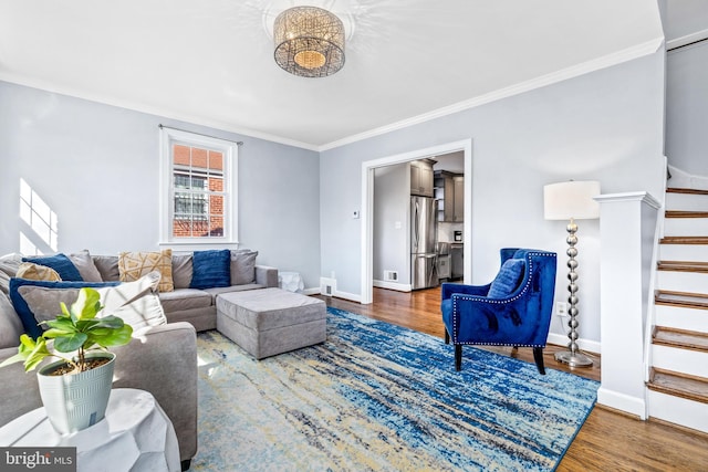 living area featuring baseboards, crown molding, stairway, and wood finished floors