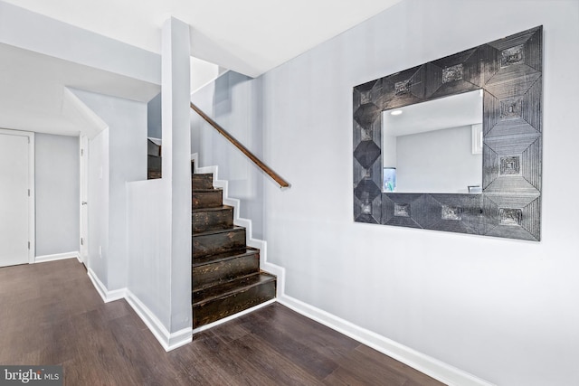 staircase with wood finished floors and baseboards