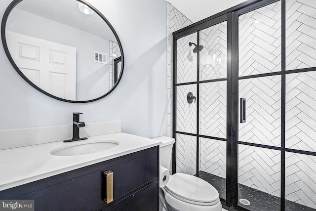 bathroom featuring toilet, a stall shower, vanity, and visible vents