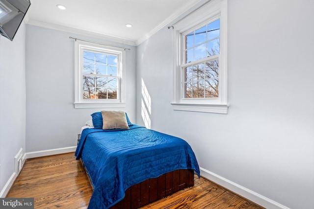 bedroom with dark wood-style floors, multiple windows, and crown molding