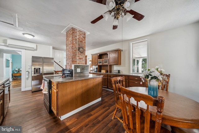 kitchen with stainless steel appliances, a textured ceiling, a wall mounted AC, a center island, and dark hardwood / wood-style flooring