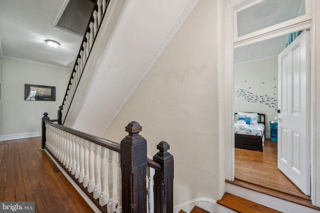 staircase with ornamental molding and wood-type flooring