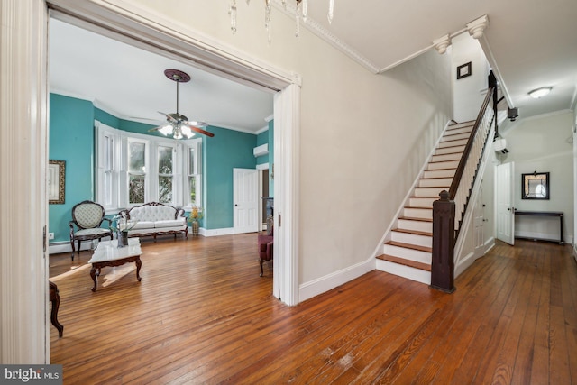 stairway featuring hardwood / wood-style flooring, ornamental molding, and ceiling fan