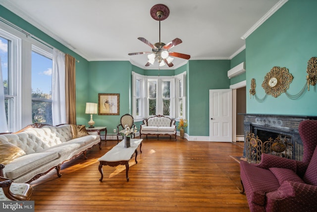 living room with a baseboard radiator, dark wood-type flooring, ornamental molding, and ceiling fan