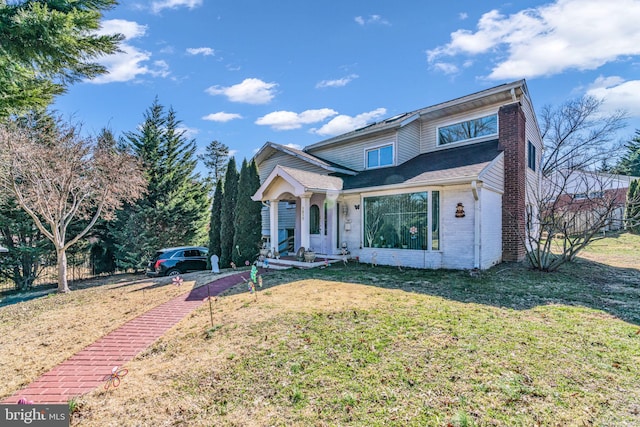 view of front of home featuring a front lawn and brick siding