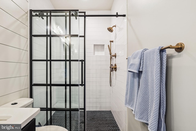 bathroom featuring vanity, a tile shower, and toilet