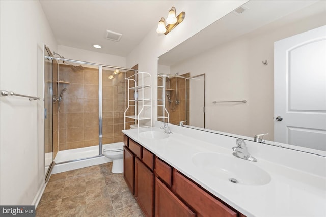 bathroom with vanity, toilet, and a shower with shower door