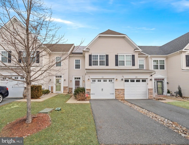 multi unit property featuring a garage and a front lawn