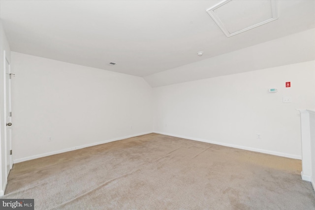 spare room with lofted ceiling and light colored carpet