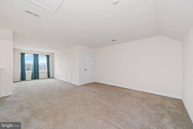 carpeted spare room featuring vaulted ceiling