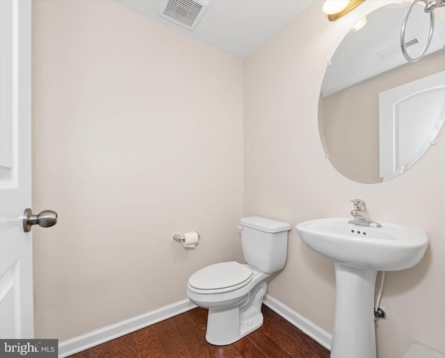 bathroom with toilet and hardwood / wood-style floors