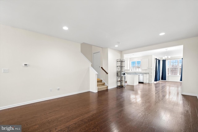 unfurnished living room featuring dark hardwood / wood-style flooring and a chandelier