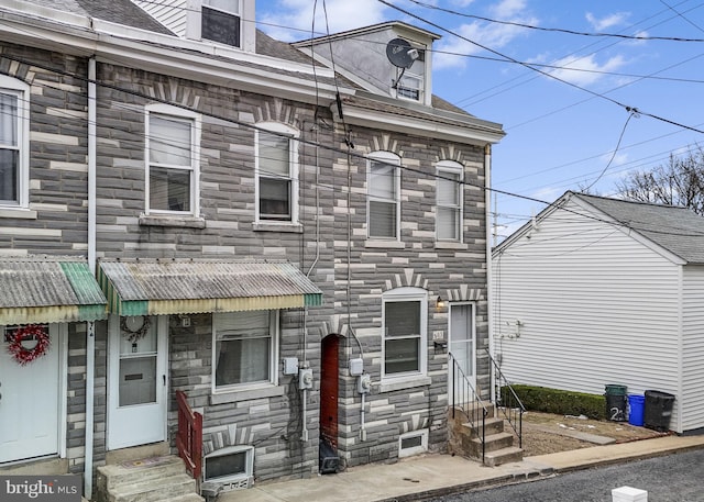 view of front facade with entry steps and stone siding