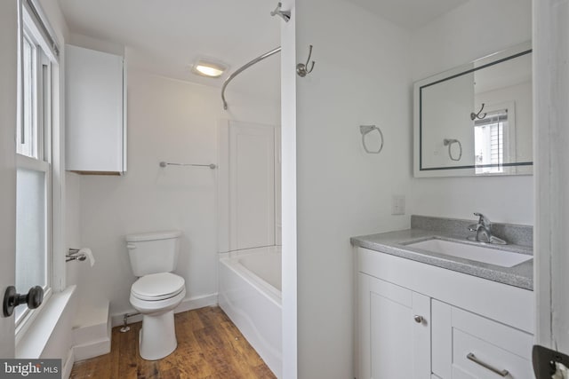 full bathroom with toilet, wood finished floors, vanity, baseboards, and  shower combination