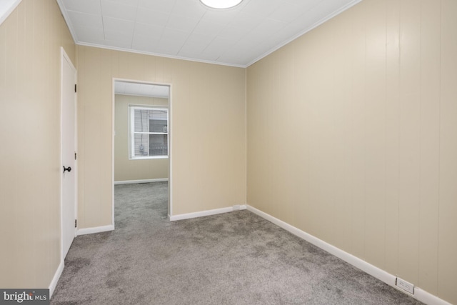 unfurnished room with baseboards, ornamental molding, and light colored carpet