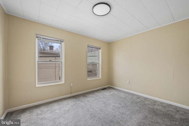 unfurnished room featuring carpet and baseboards