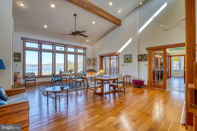 dining space with beam ceiling, french doors, a wealth of natural light, and a ceiling fan