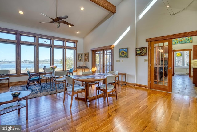 dining area featuring baseboards, beamed ceiling, light wood-style flooring, french doors, and high vaulted ceiling