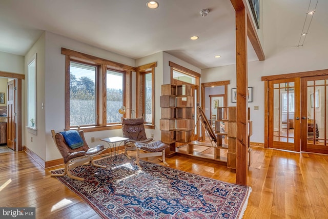 living area with light wood finished floors, recessed lighting, french doors, and baseboards