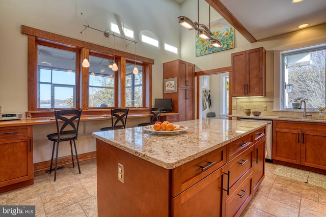 kitchen with a kitchen island, tasteful backsplash, a wealth of natural light, and a sink